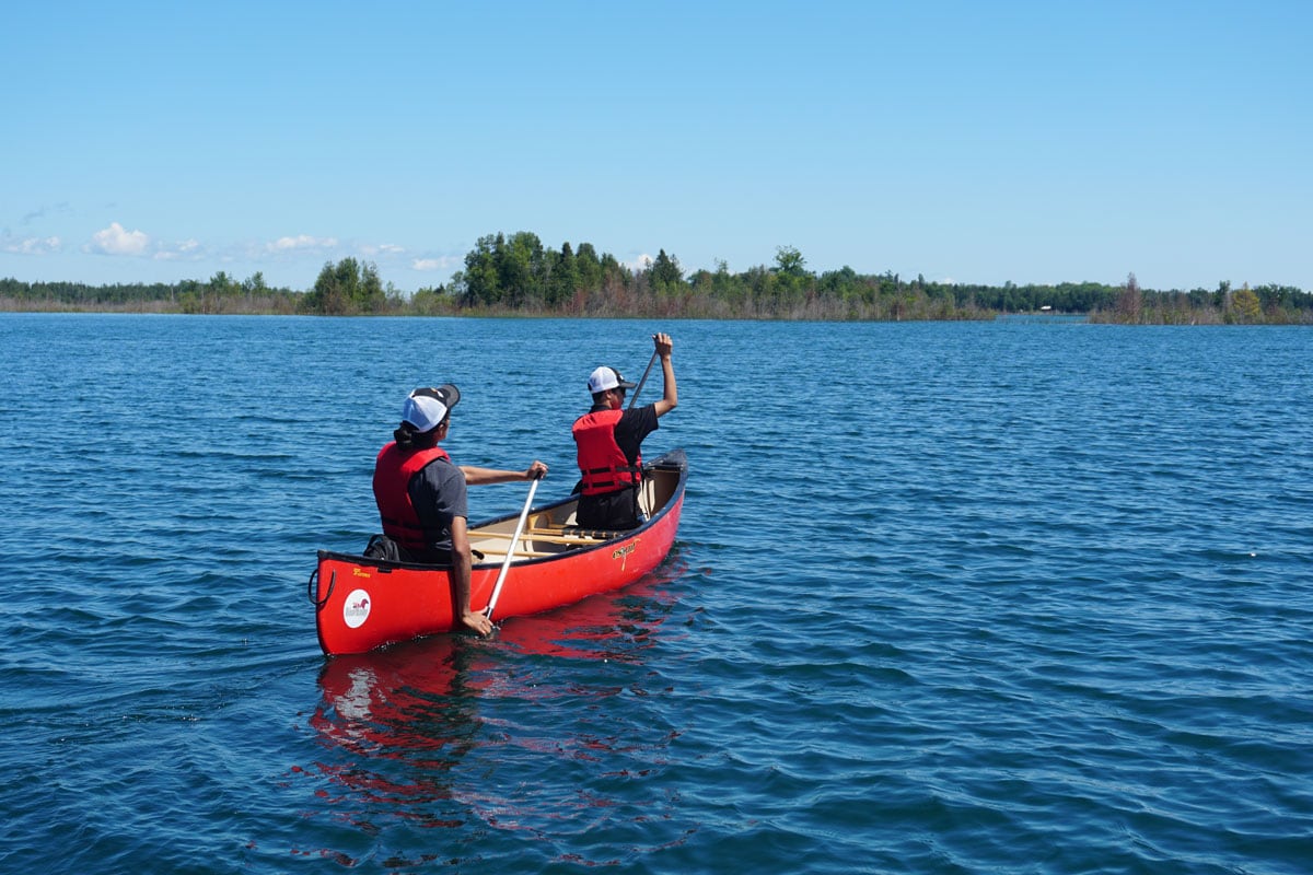 Daily-Experiences-bay-of-beaver2 Two people rowing a canoe on a lake